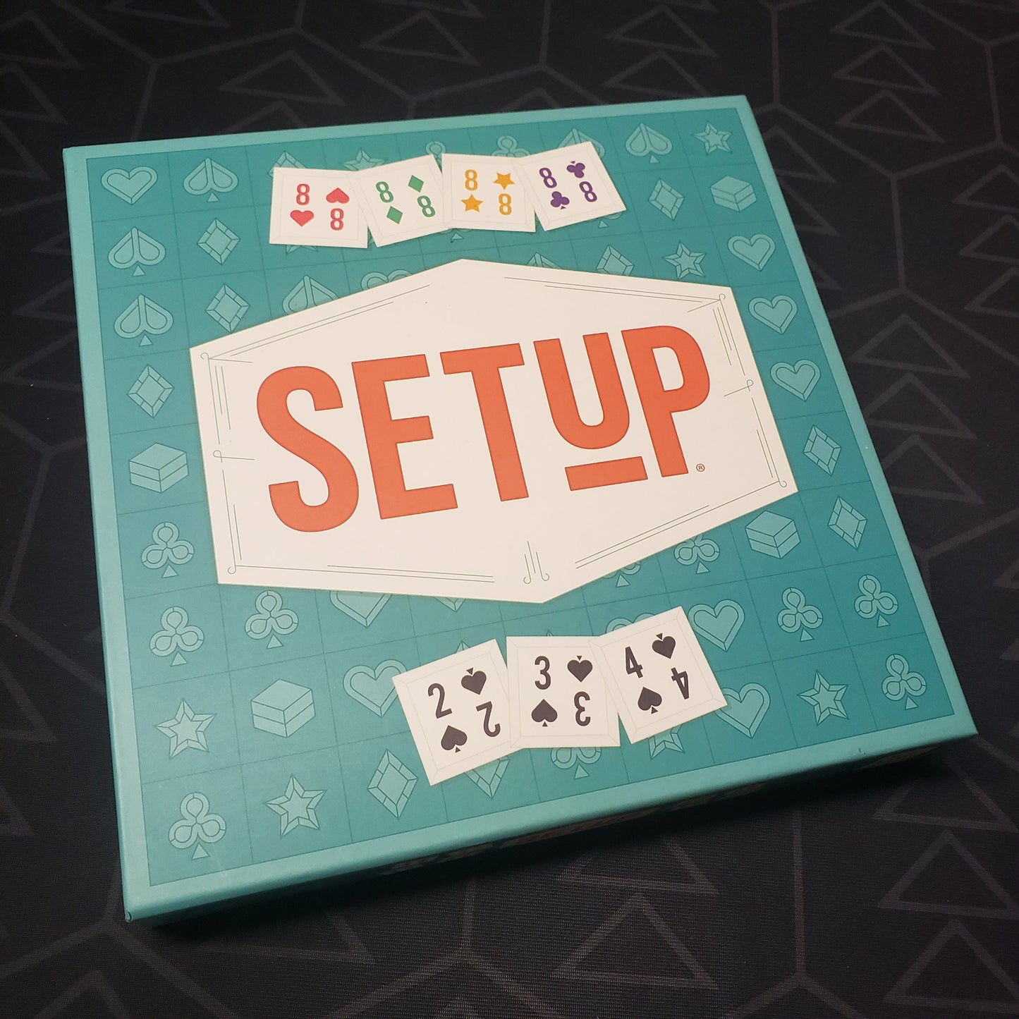 Image shows the front cover of the box for the SETUP board game