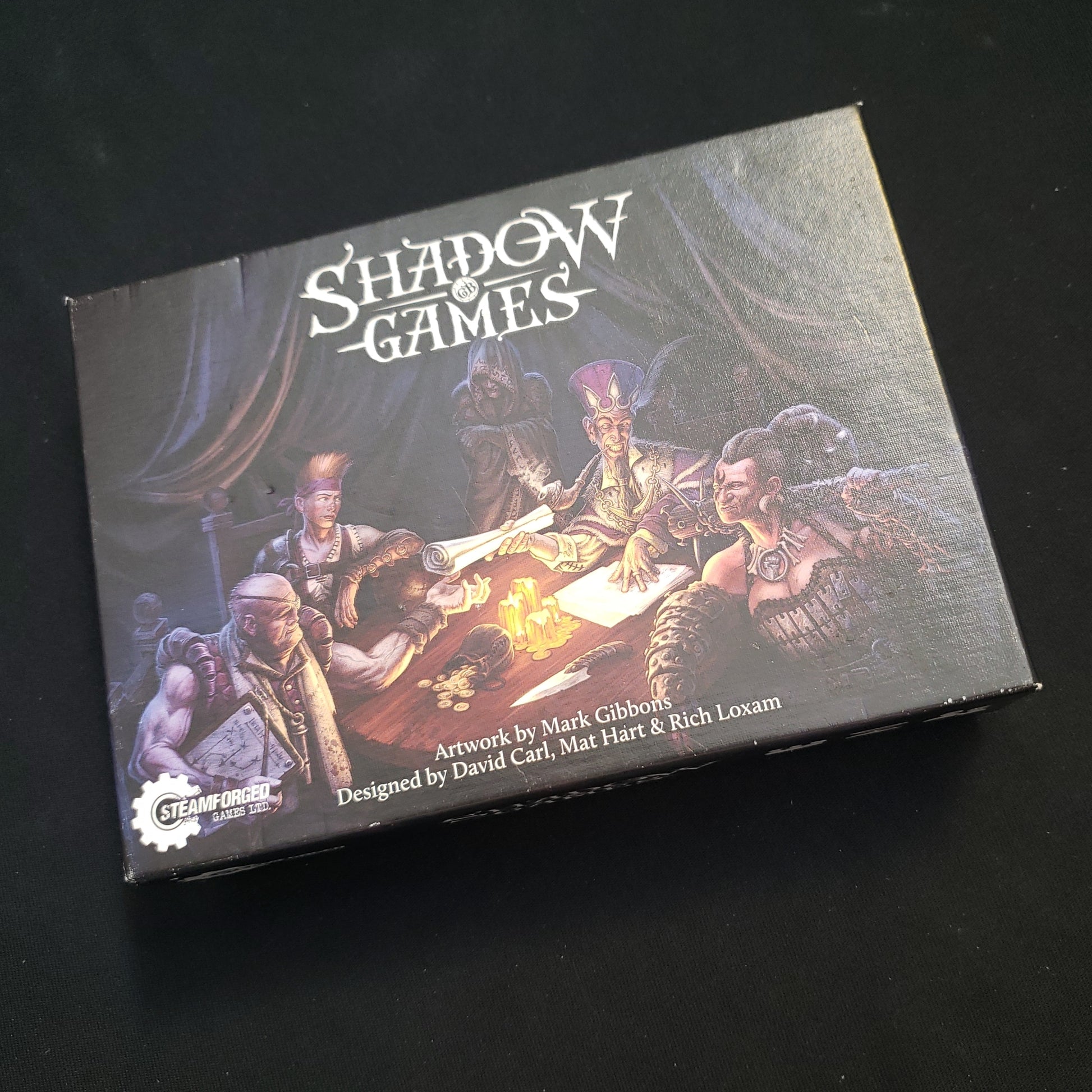 Image shows the front cover of the box of the Shadow Games card game