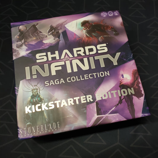Image shows the front cover of the Kickstarter Edition box for the card game Shards of Infinity: Saga Collection