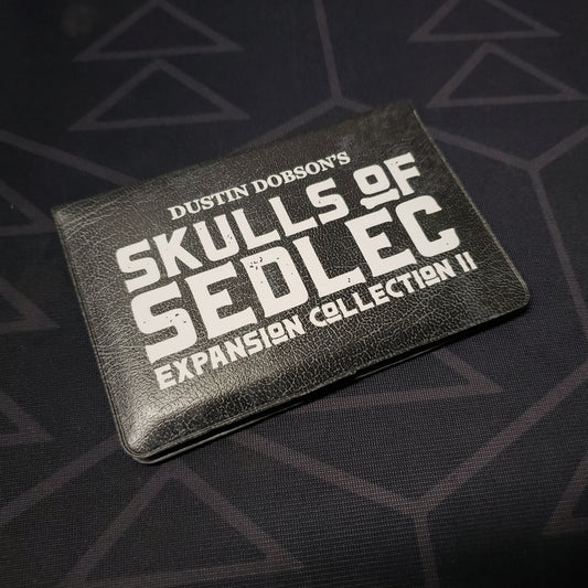 Image shows the front of the card wallet for the Expansion Collection II pack for the card game Skulls of Sedlec