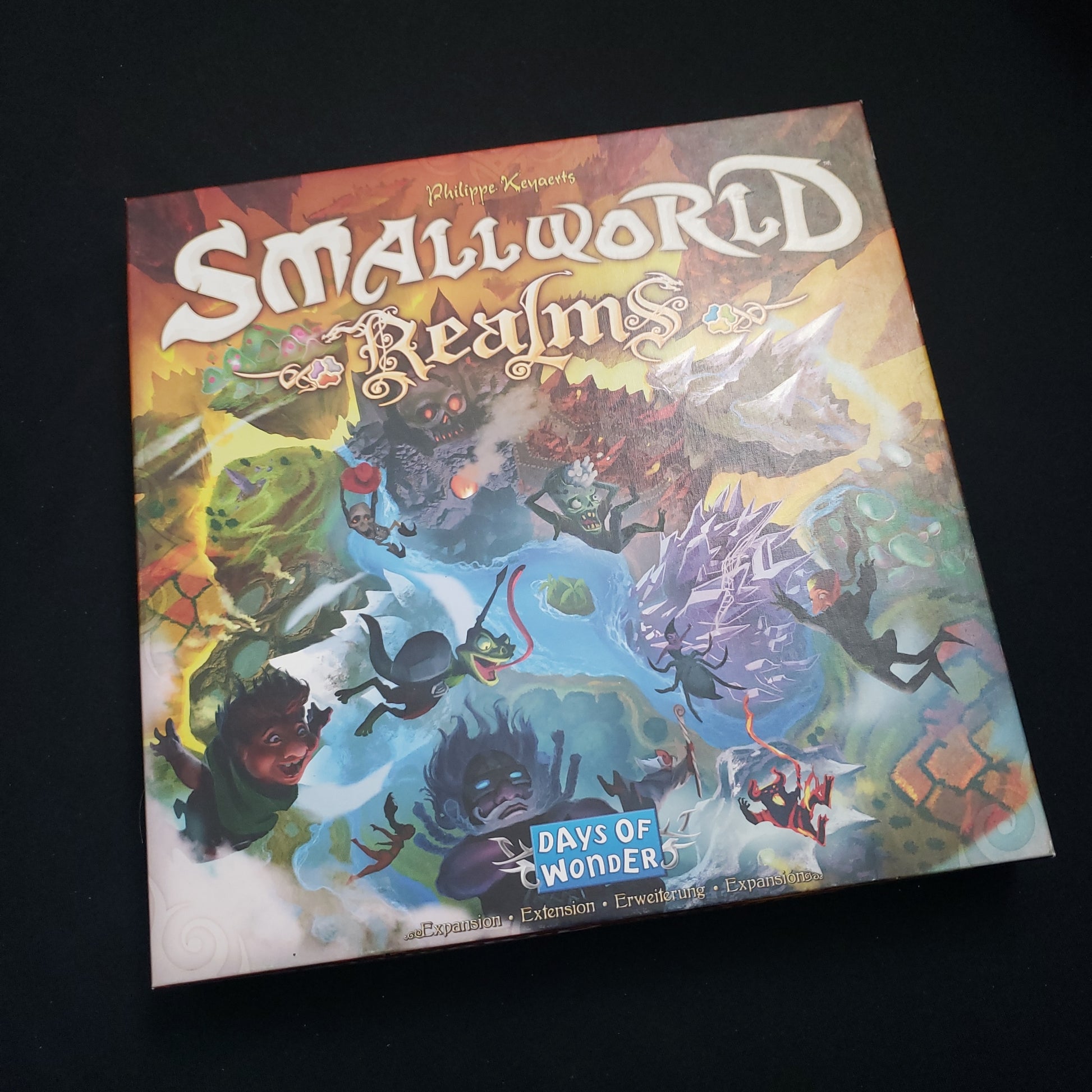 Image shows the front cover of the box of the Realms expansion for the board game Small World
