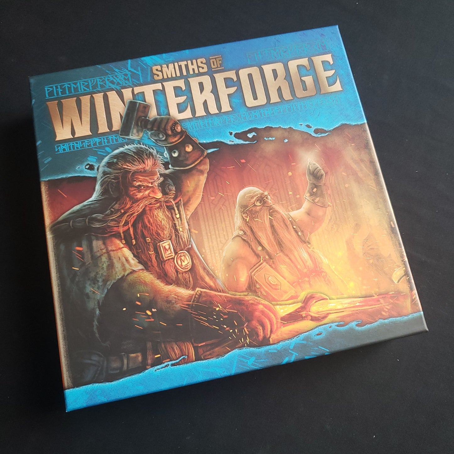 Image shows the front cover of the box of the Smiths of Winterforge board game