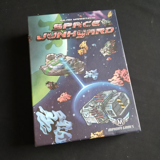 Image shows the front cover of the box of the Space Junkyard board game