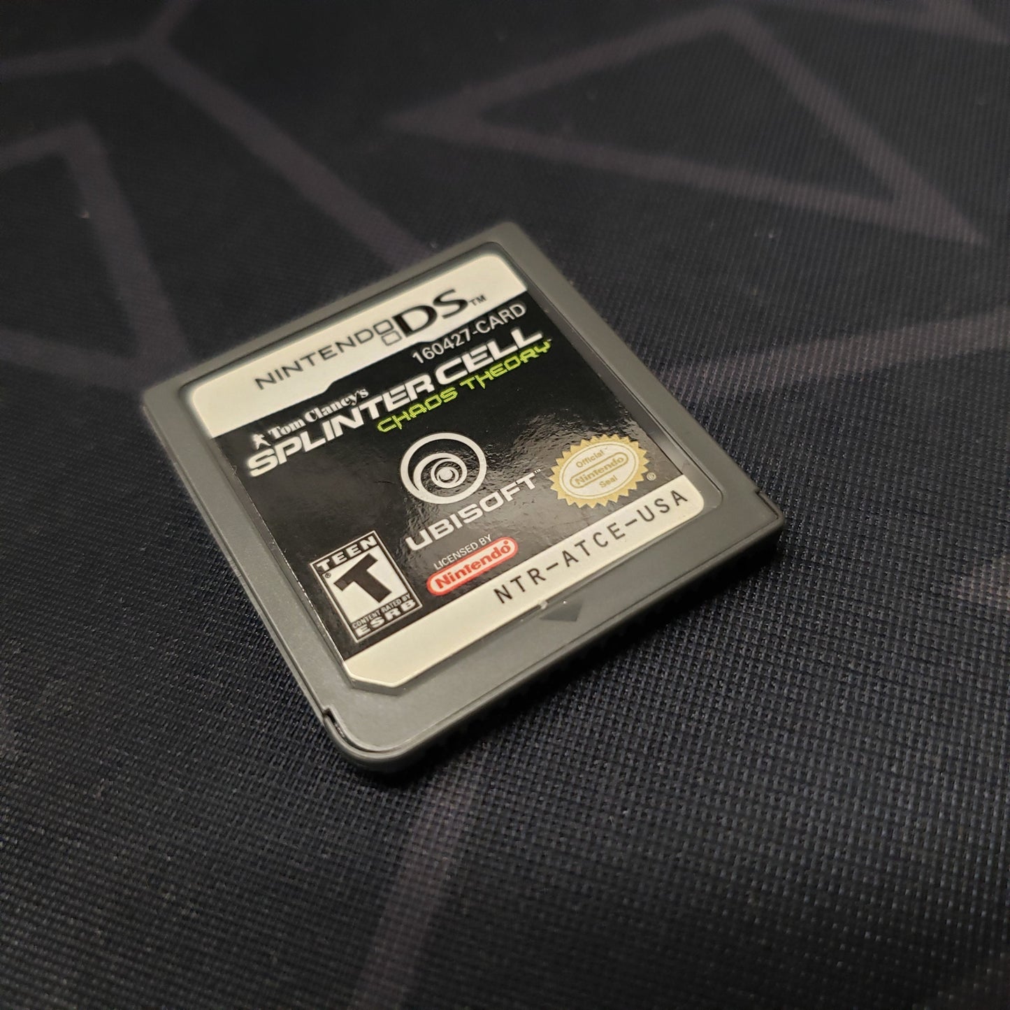 Image shows the front of the cartridge for the video game Splinter Cell: Chaos Theory for Nintendo DS