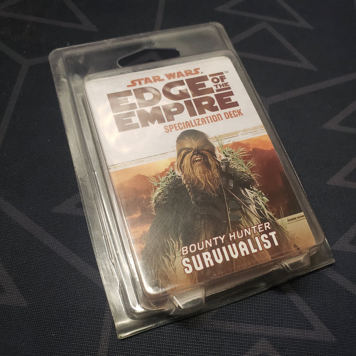 Image shows the front of the clamshell packaging for the Bounty Hunter Survivalist Deck for the roleplaying game Star Wars: Edge of the Empire