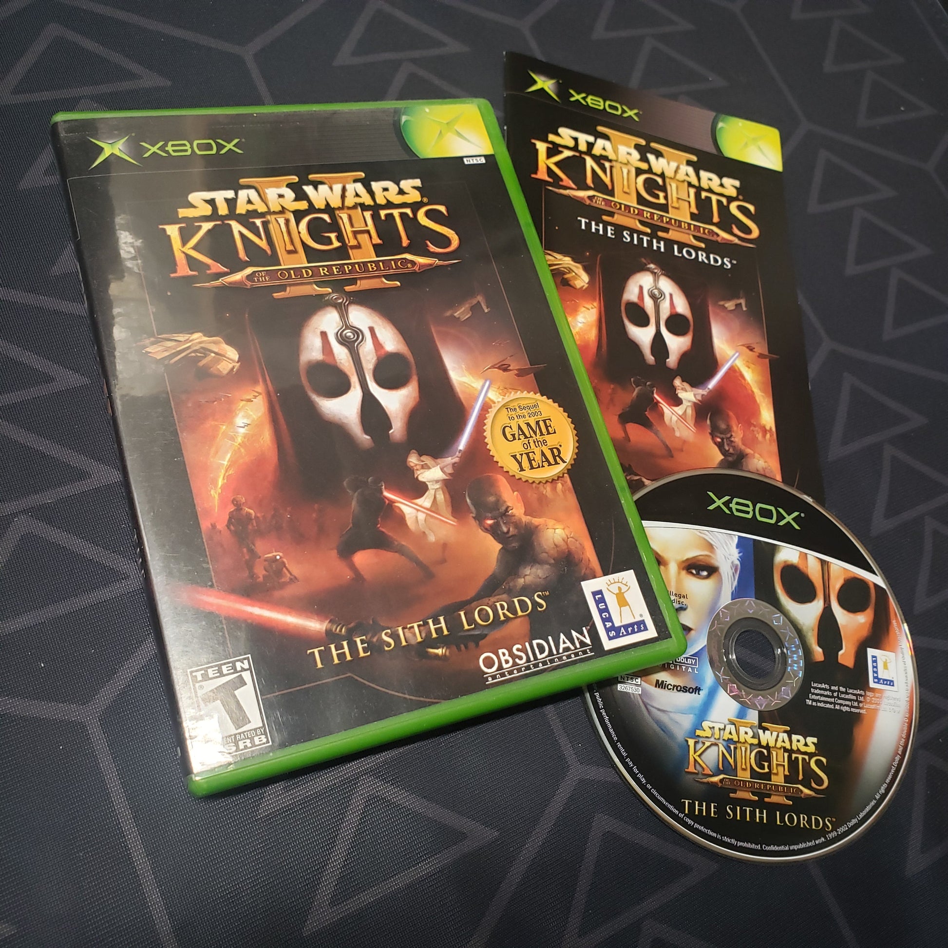 Image shows the case, manual and disc for the video game Star Wars: Knights of the Old Republic II - The Sith Lords for the original Xbox