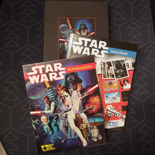 Image shows the front covers of the two books as well as the slipcase for the 30th Anniversary Edition release for Star Wars: The Roleplaying Game