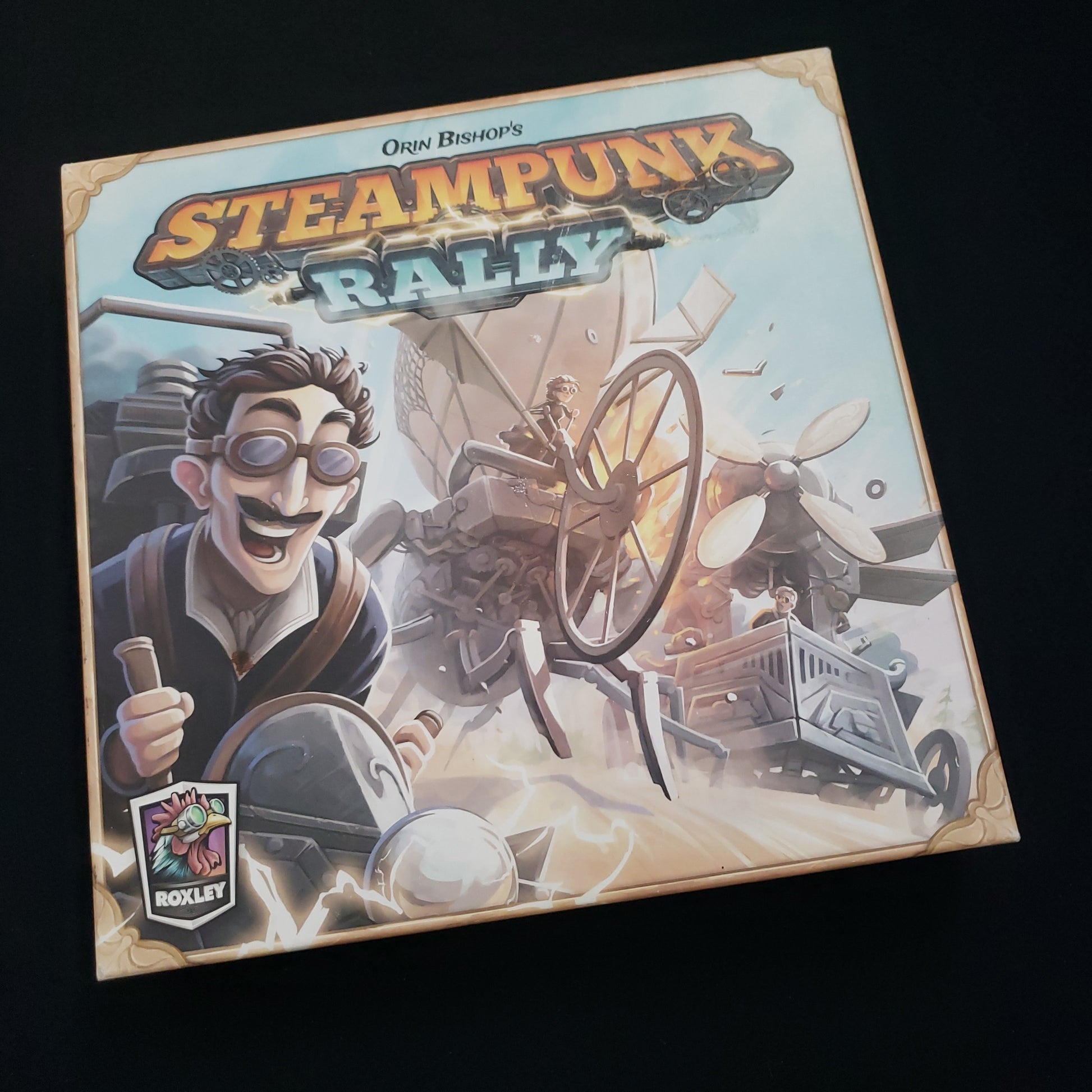 Image shows the front cover of the box of the Steampunk Rally board game