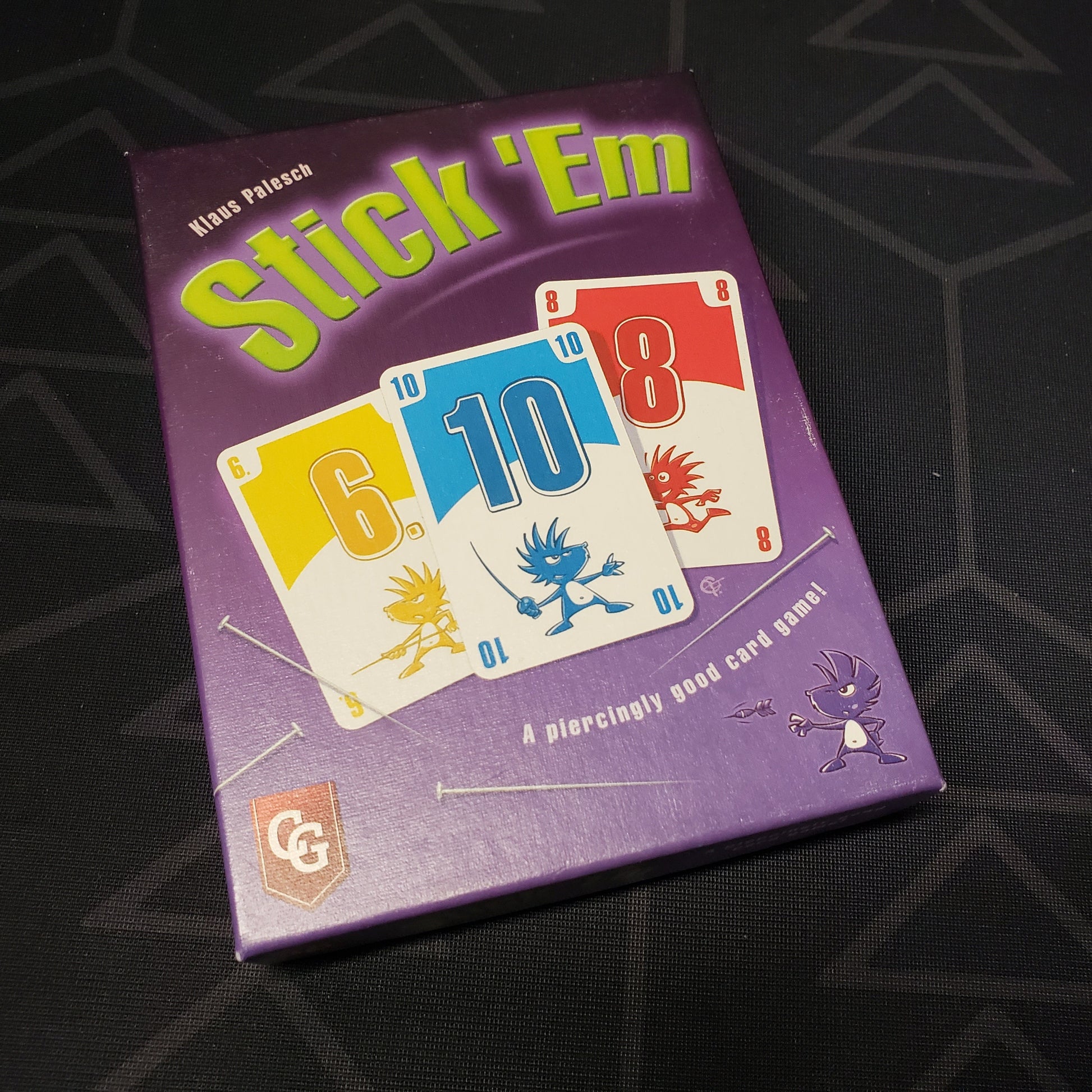 Image shows the front cover of the box for the Stick 'Em card game