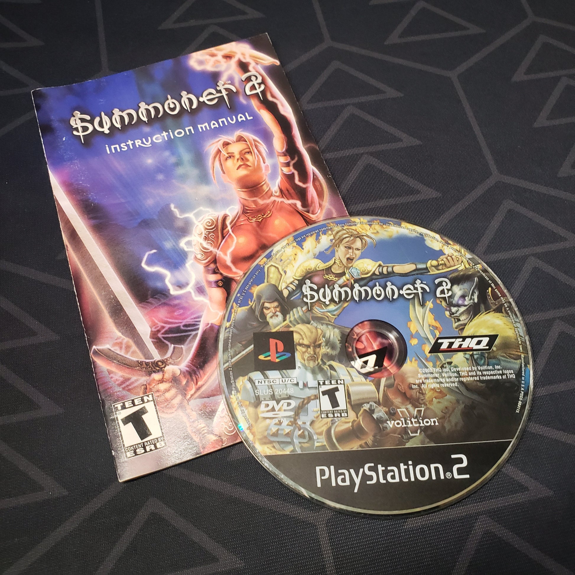 Image shows the manual and disc for the video game Summoner 2 for Playstation 2