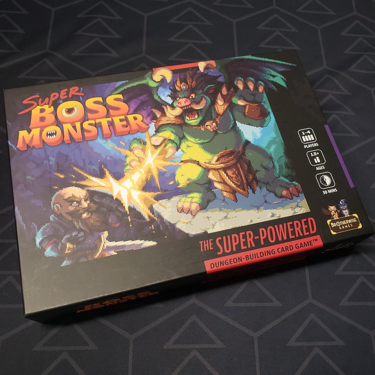 Image shows the front cover of the box for the Super Boss Monster board game