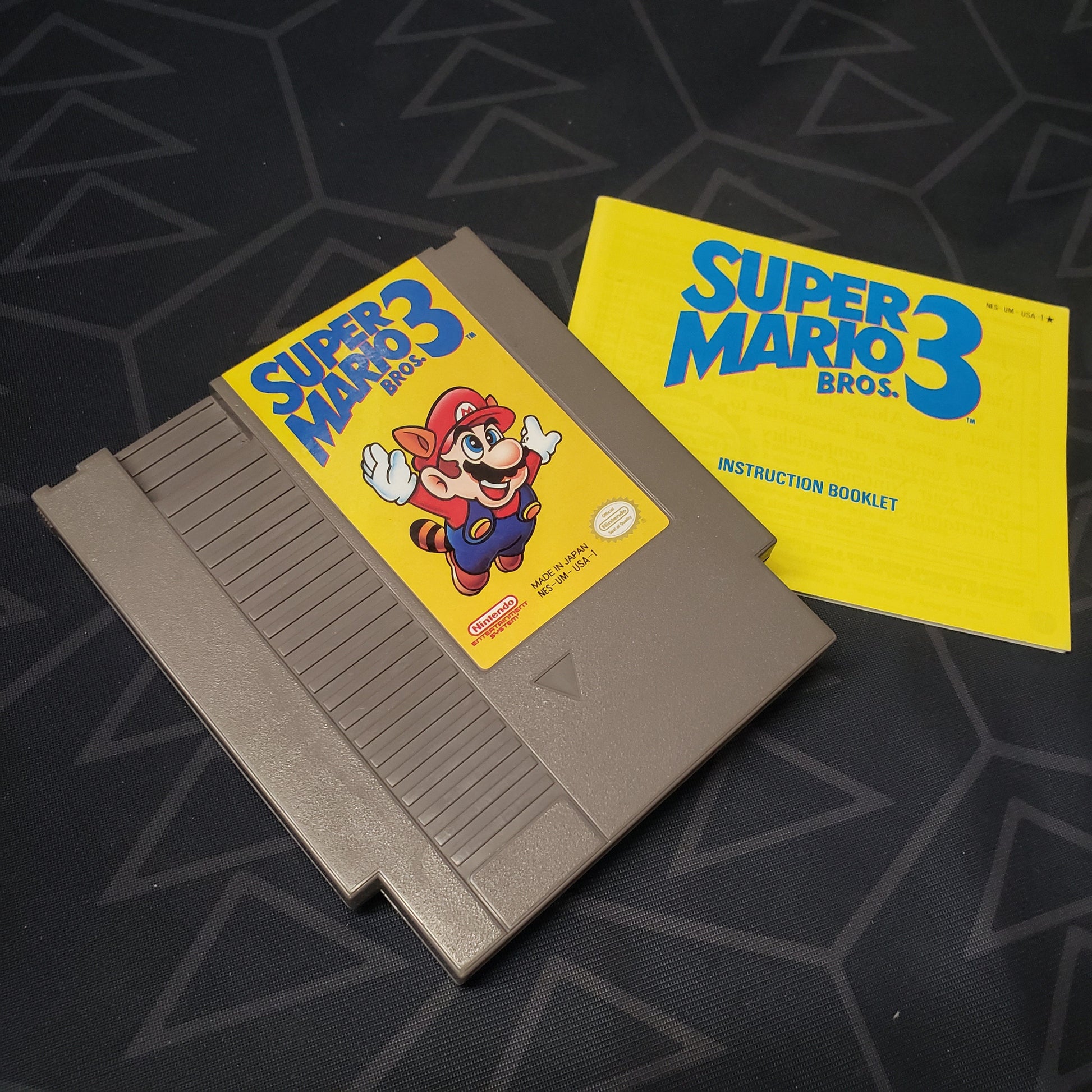 Image shows the front of the cartridge & the manual for the video game Super Mario Bros. 3 for the Nintendo Entertainment System