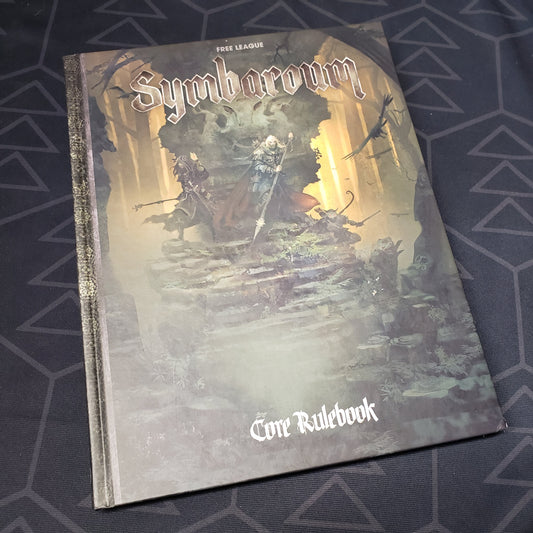 Image shows the front cover of the core rulebook for the roleplaying game Symbaroum