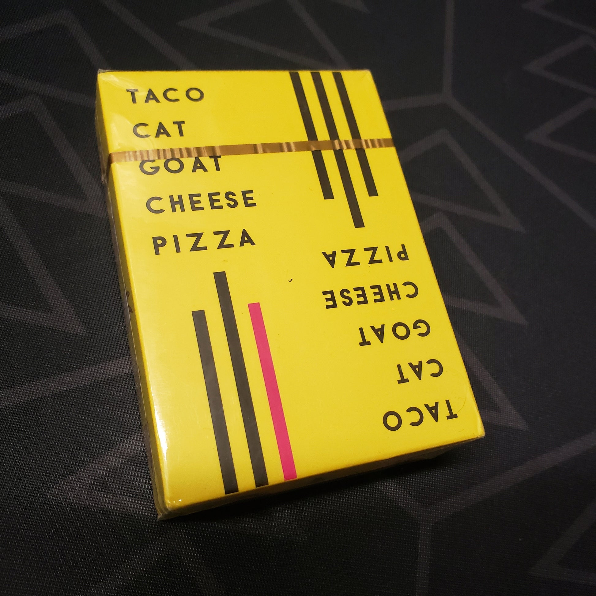 Image shows the front cover of the box for the Taco Cat Goat Cheese Pizza card game