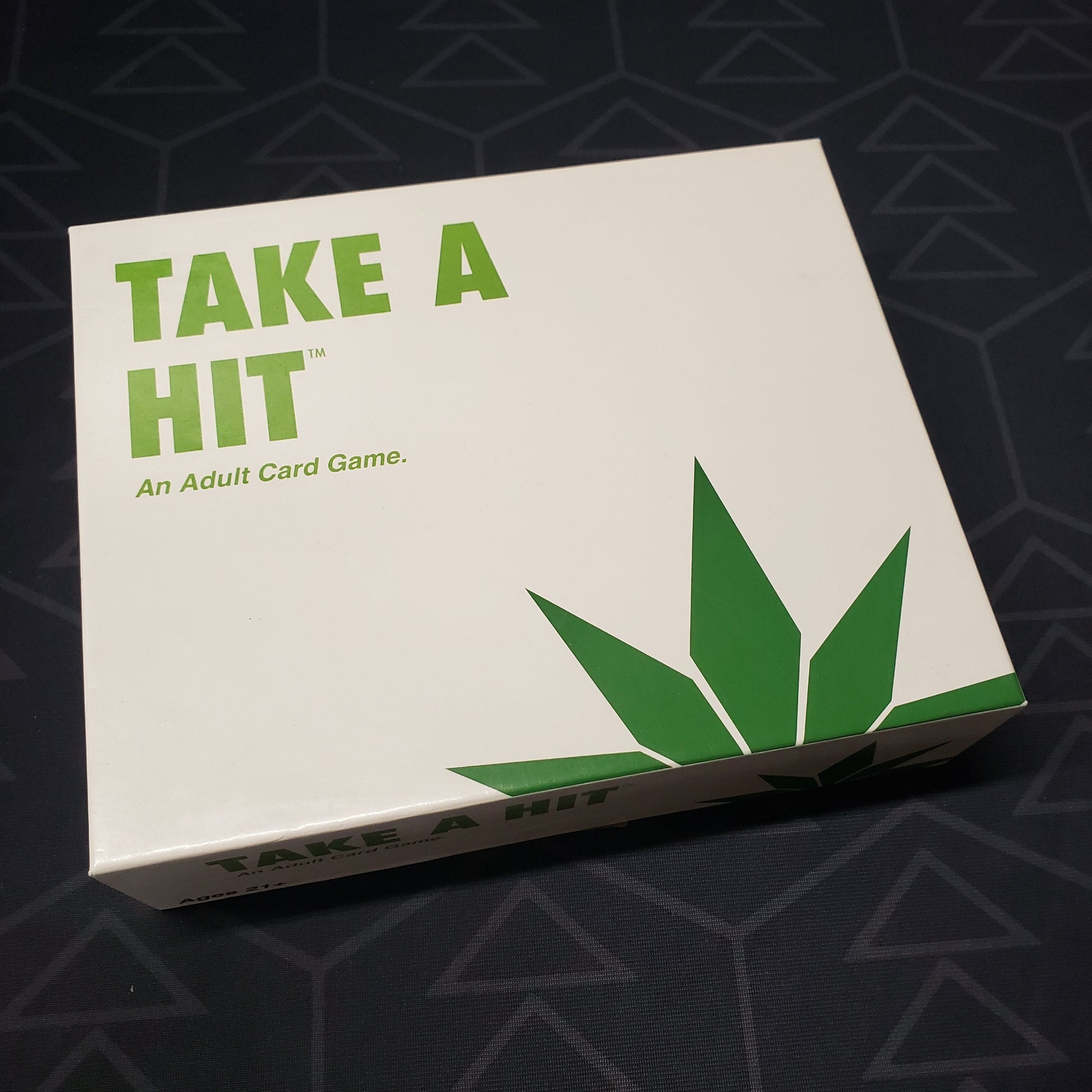 Image shows the front cover of the box for the Take a Hit card game