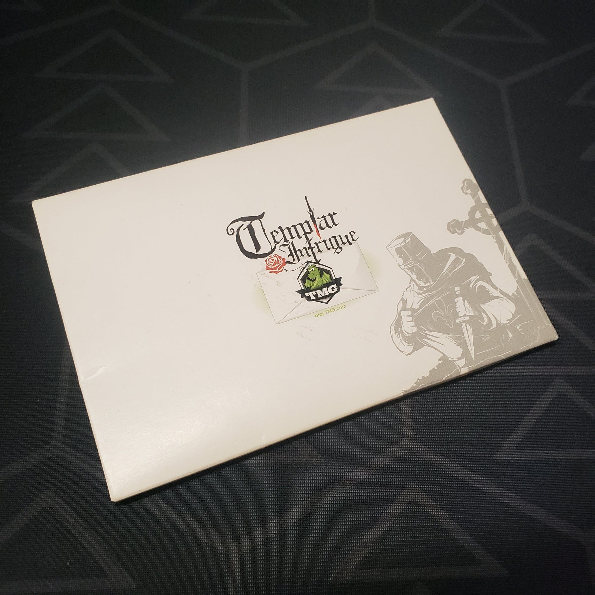 Image shows the front cover of the box for the Templar Intrigue card game