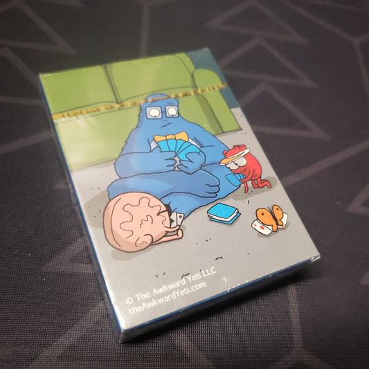 Image shows the front cover of the box for the Awkward Yeti pack of Collectible Playing Cards