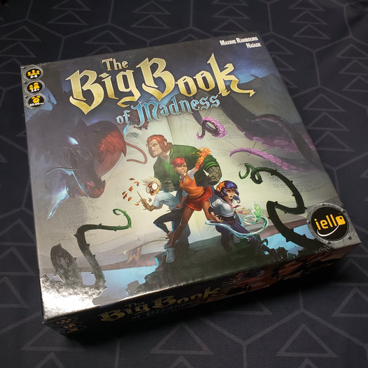 Image shows the front cover of the box for the Big Book of Madness board game