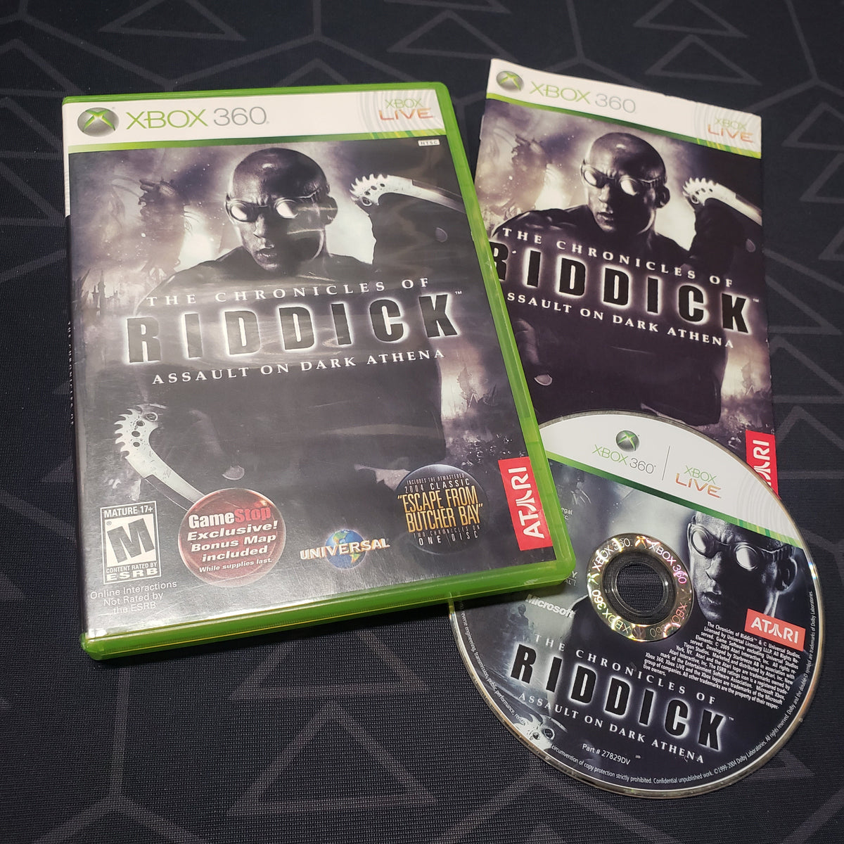 Image shows the case, manual and disc for the video game The Chronicles of Riddick: Assault on Dark Athena for Xbox 360
