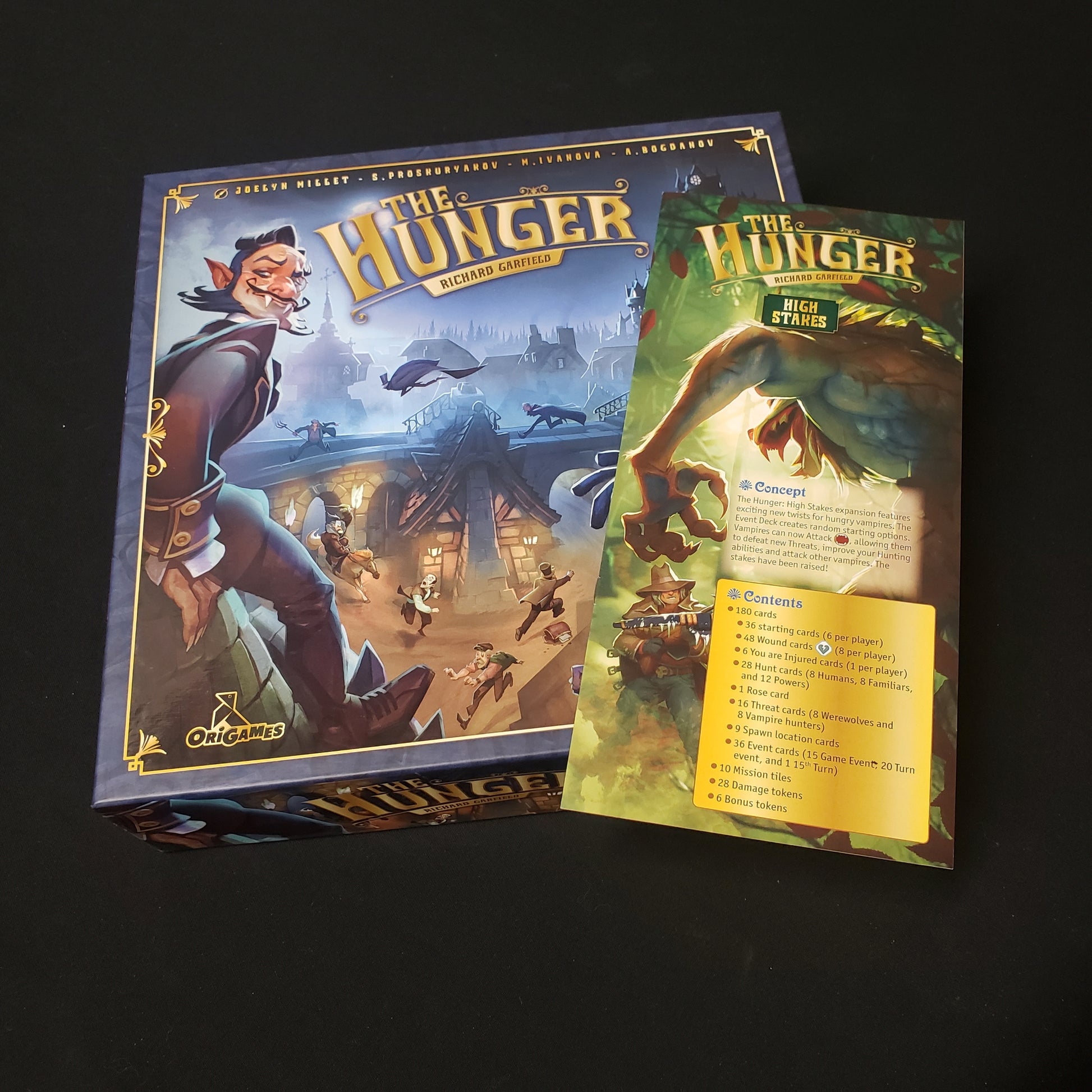 Image shows the front cover of the box of the Hunger board game, with the instructions for the High Stakes expansion sitting on top of it