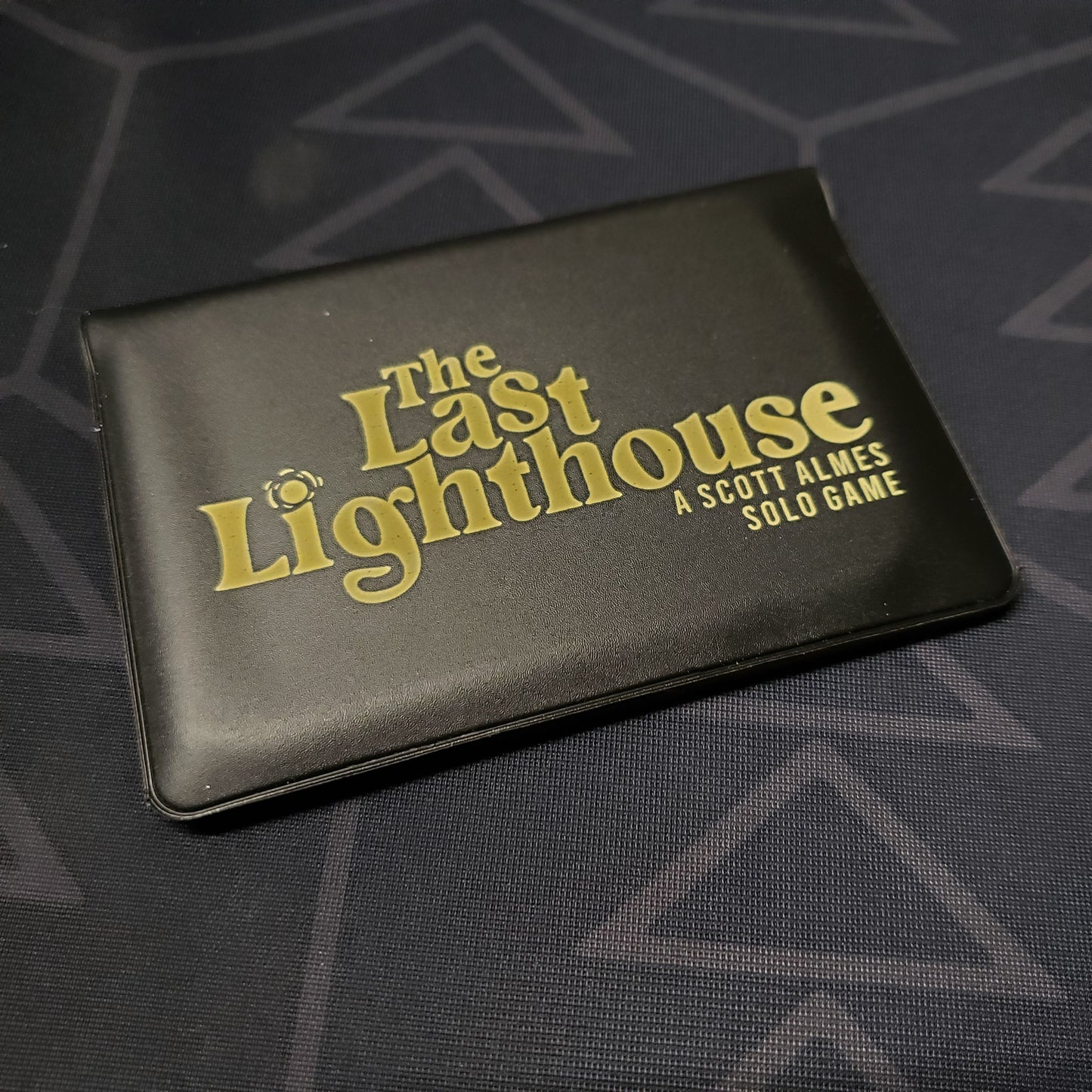 Image shows the front of the card wallet for the card game The Last Lighthouse