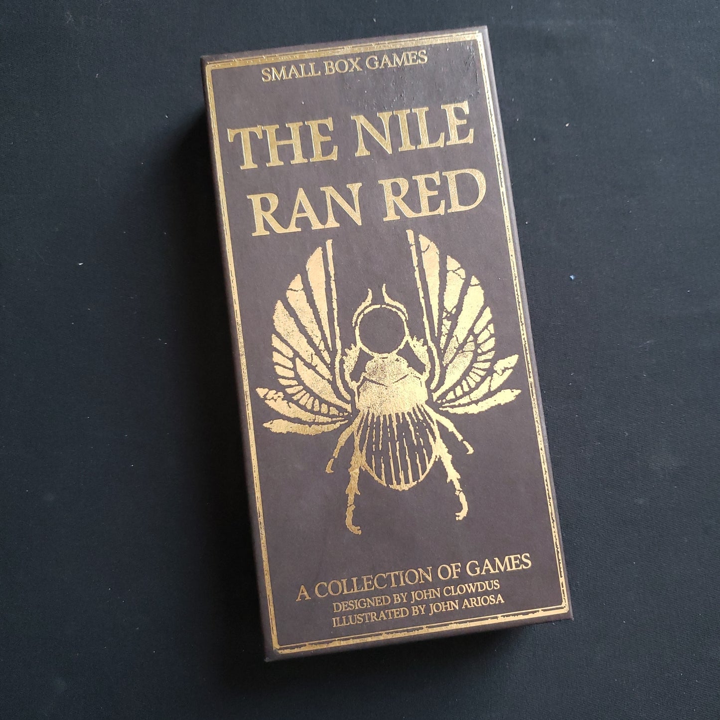 Image shows the front cover of the box of the Nile Ran Red set of card games