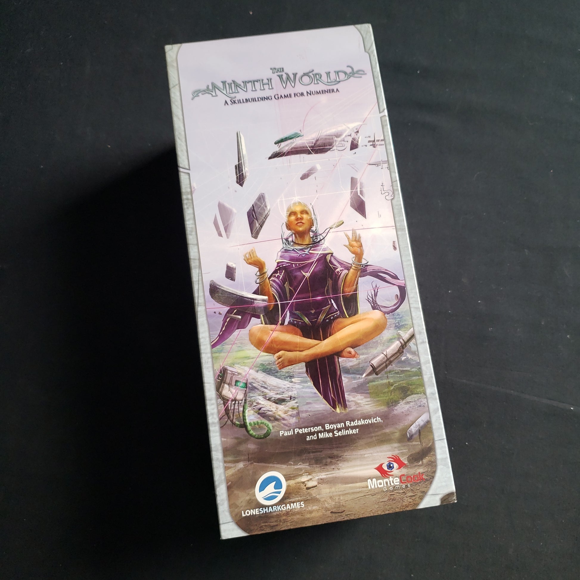 Image shows the front cover of the box of the Ninth World card game