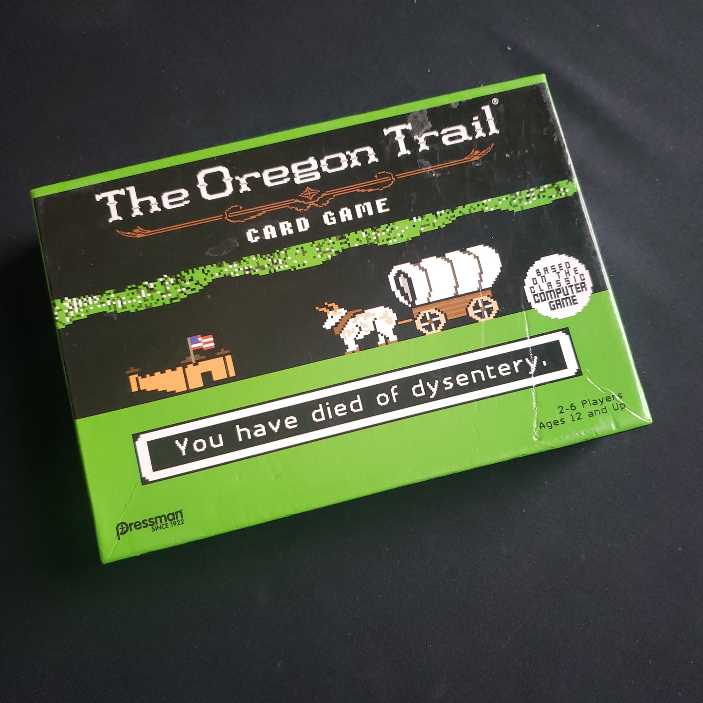 Image shows the front cover of the box of the Oregon Trail card game