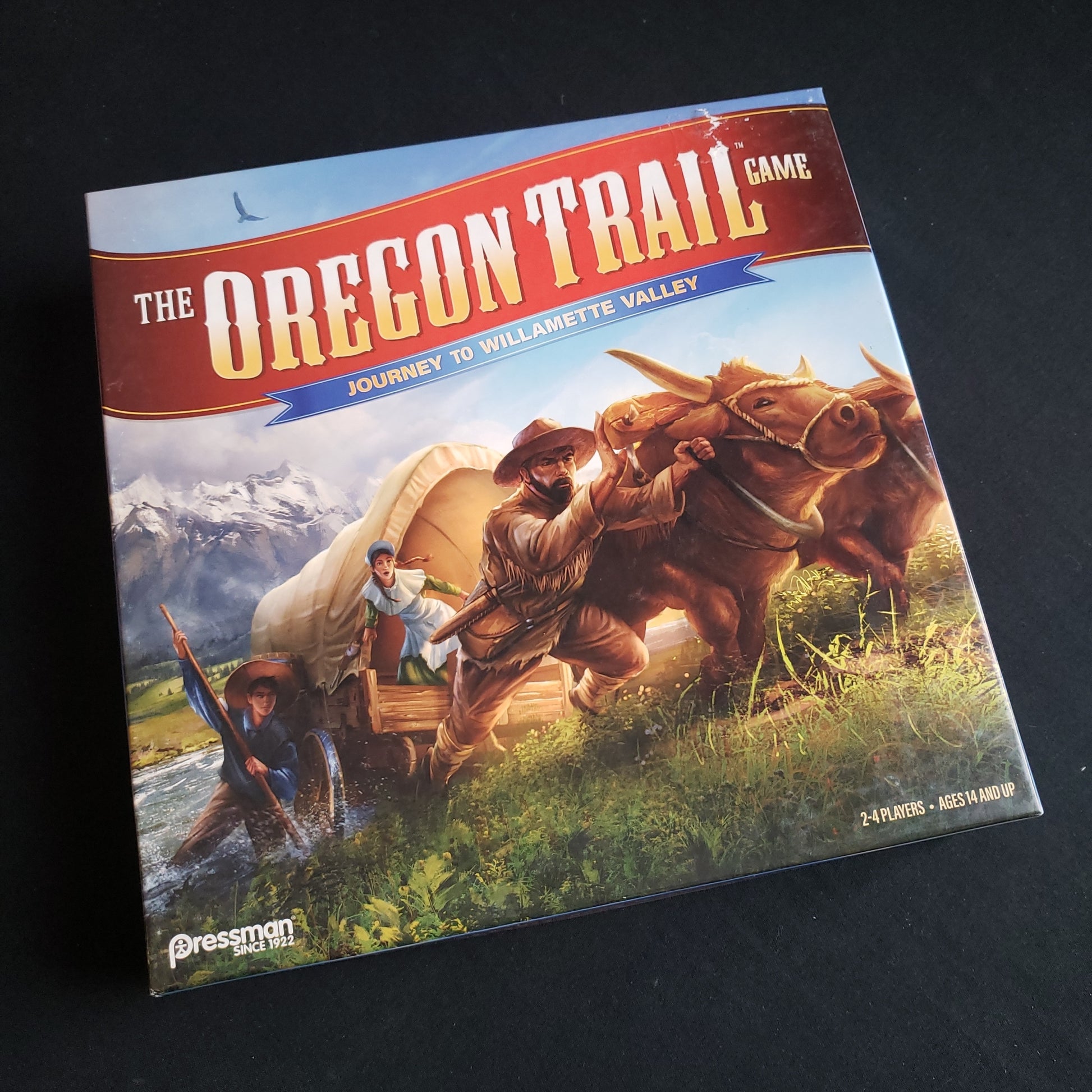 Image shows the front cover of the box of the Oregon Trail: Journey to Willamette Valley board game