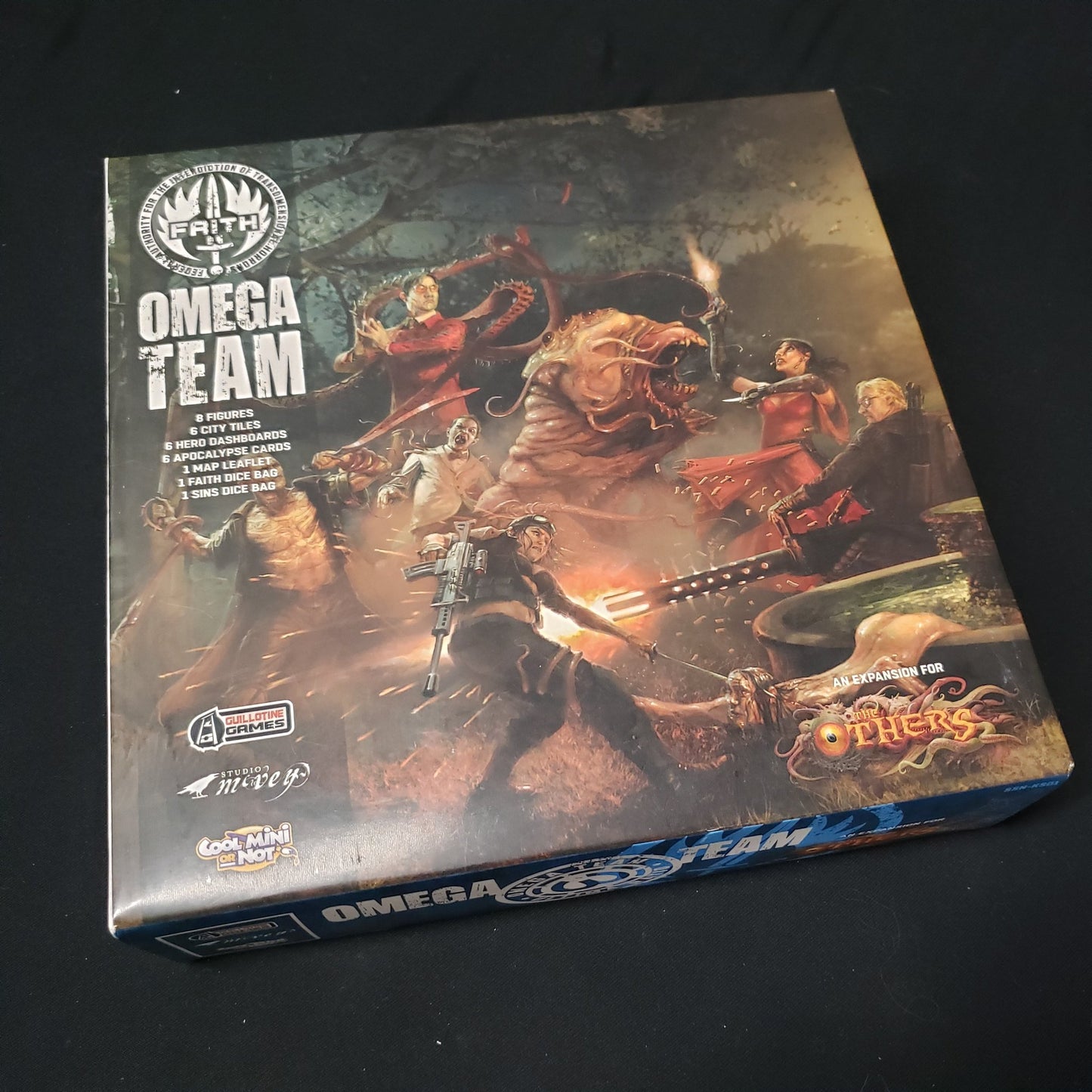 Image shows the front cover of the box of the Omega Team expansion for the board game The Others