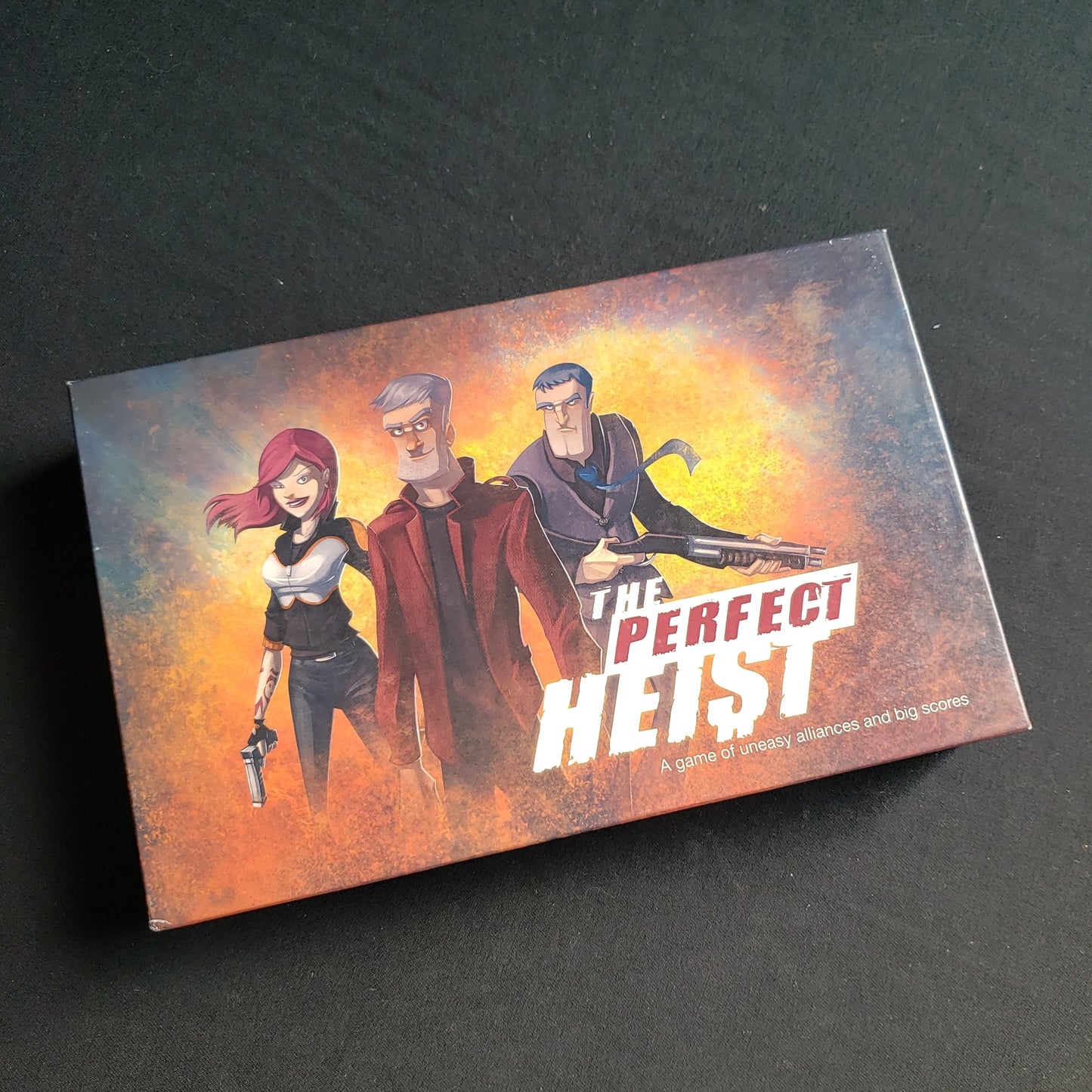 Image shows the front cover of the box of the Perfect Heist board game