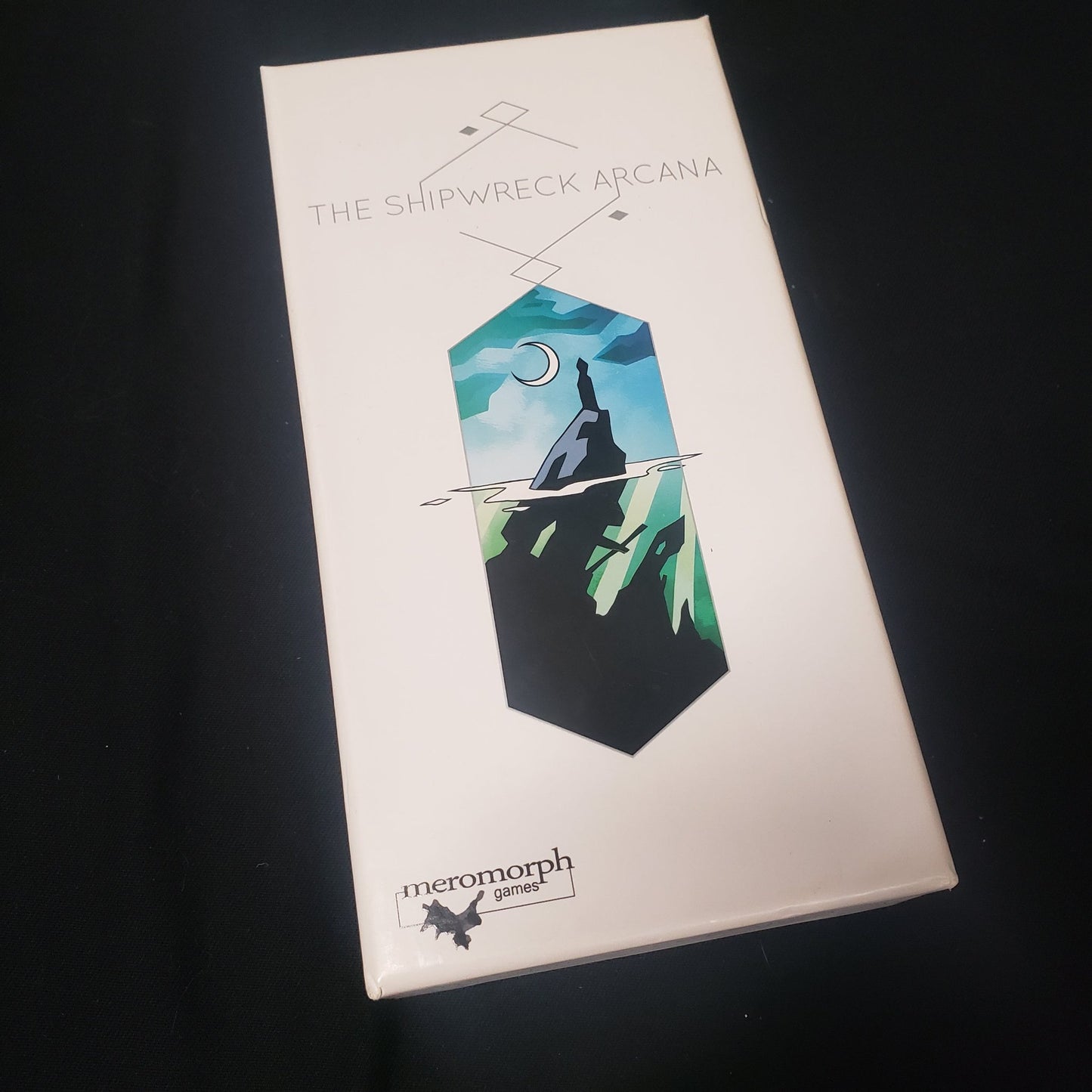 Image shows the front cover of the box of the Shipwreck Arcana card game
