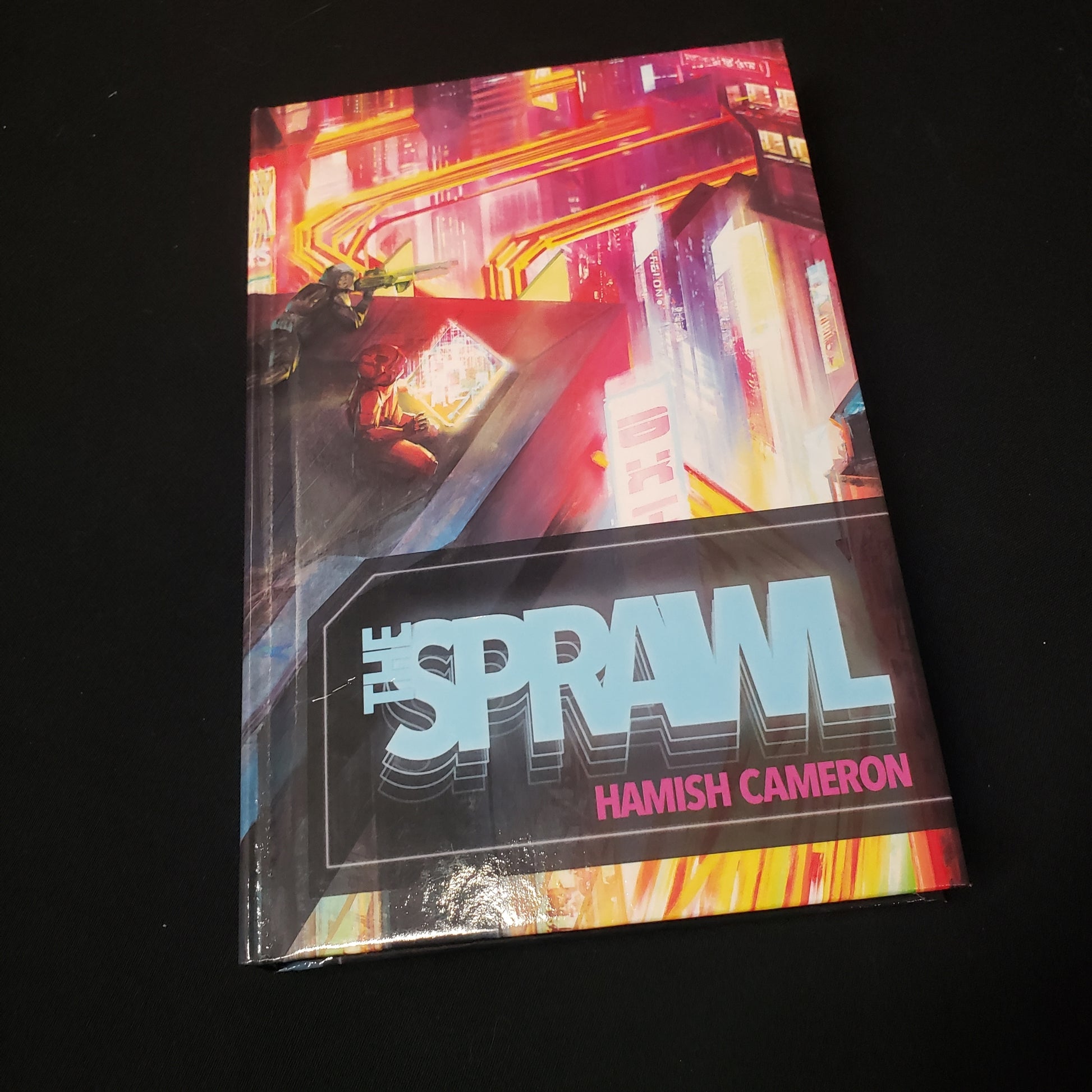 Image shows the front cover of the core rulebook for the The Sprawl roleplaying game