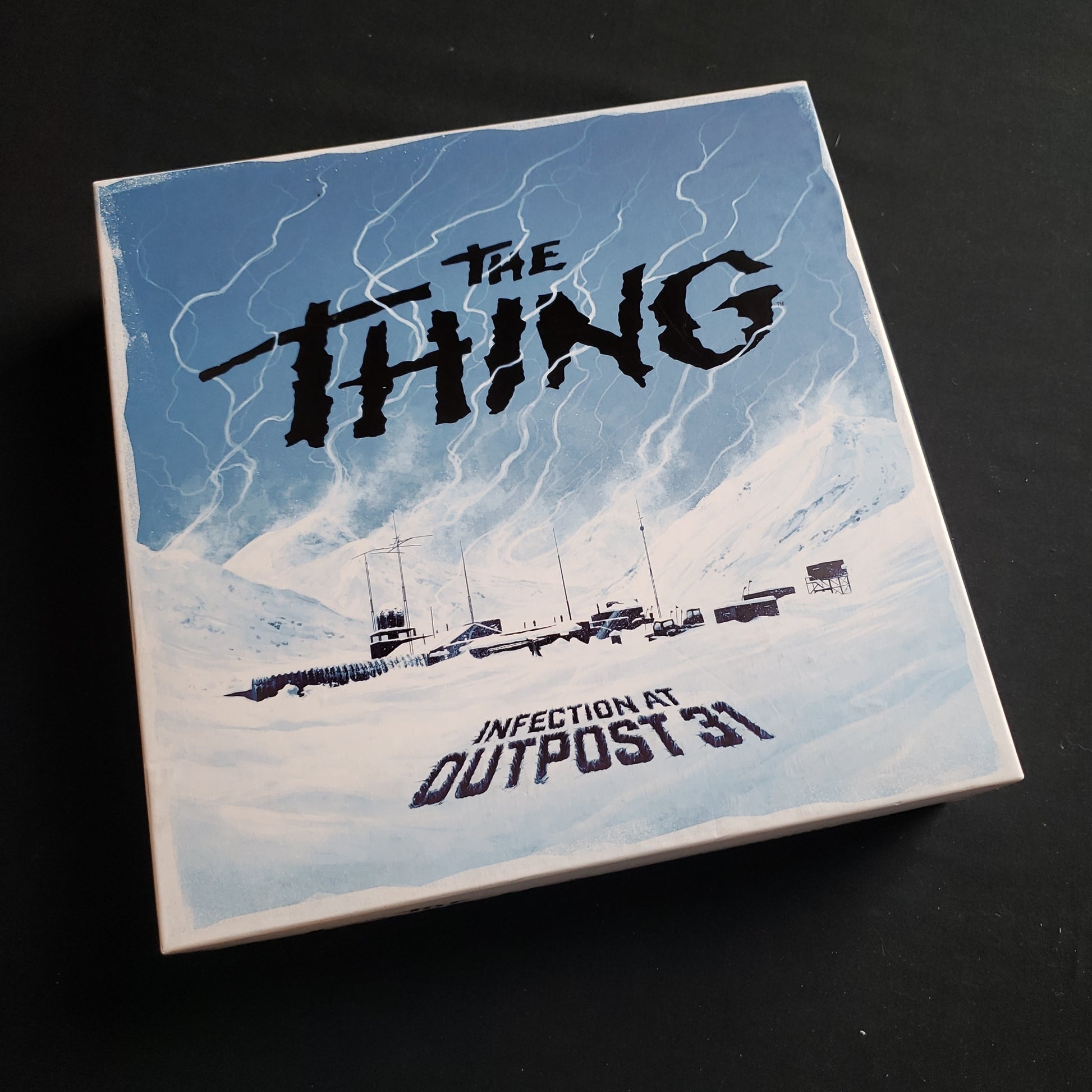 Image shows the front cover of the box of The Thing: Infection at Outpost 31 board game