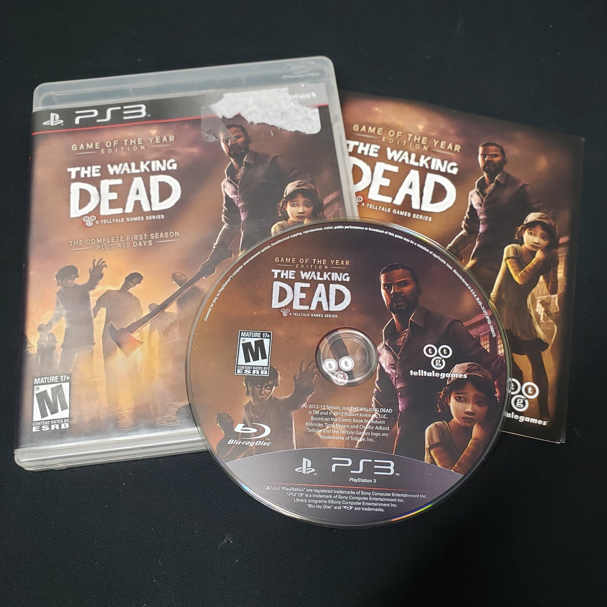 Image shows the case, manual & disc for the video game The Walking Dead: Season One - Game of the Year Edition for Playstation 3