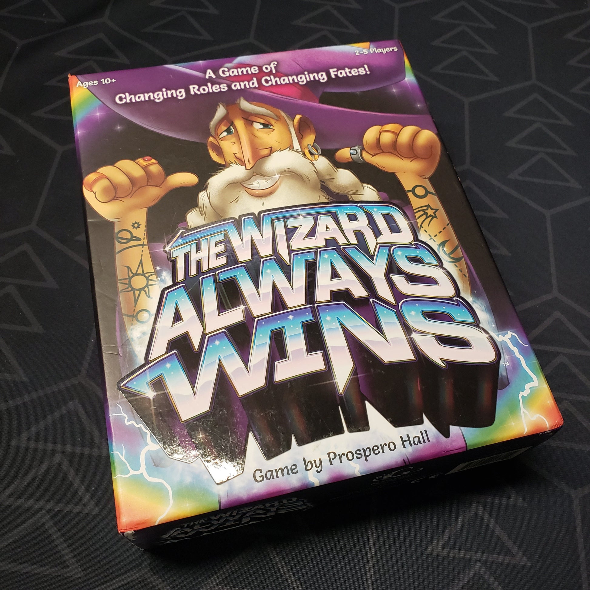 Image shows the front cover of the box for the board game The Wizard Always Wins