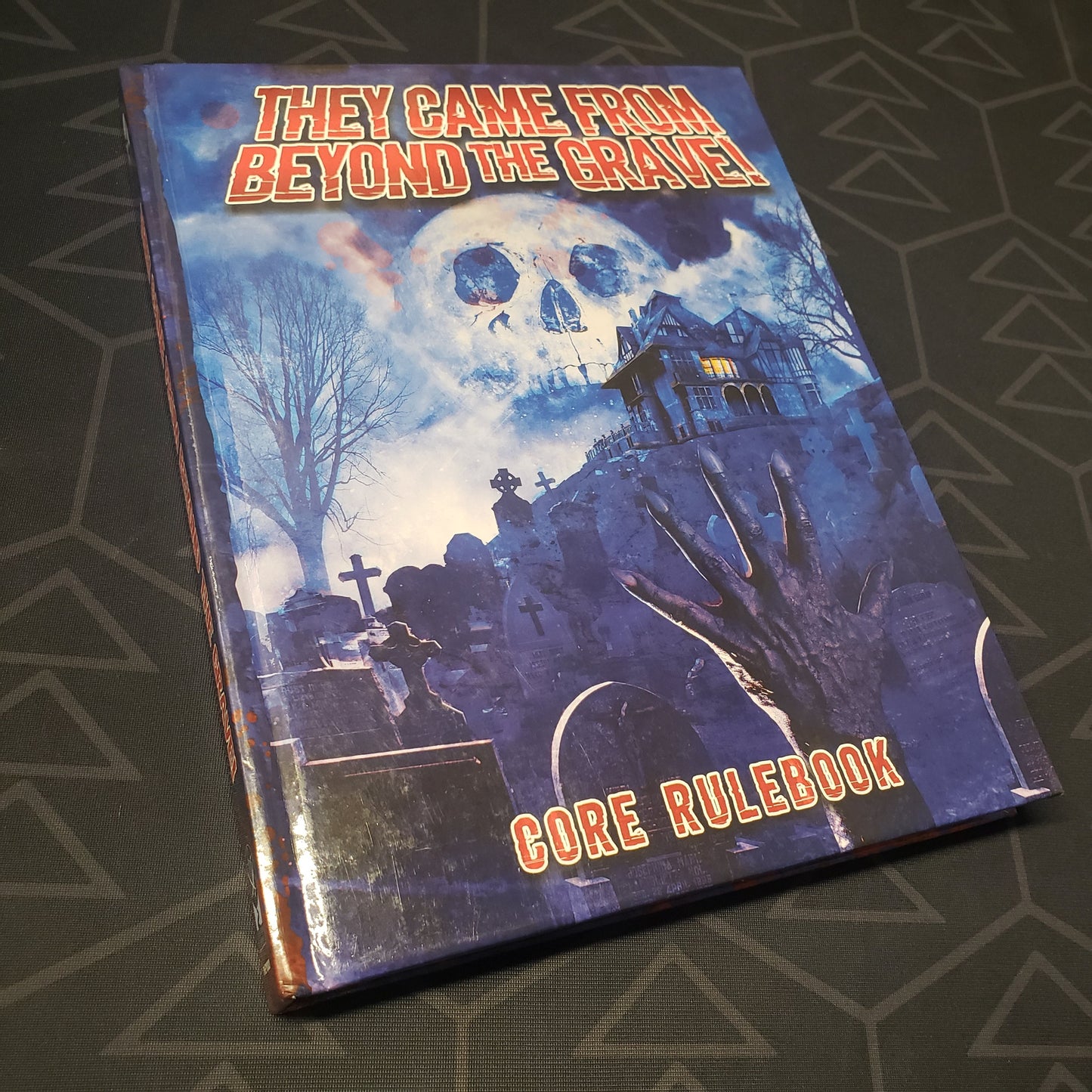 Image shows the front cover of the core rulebook for the roleplaying game They Came From Beyond the Grave!