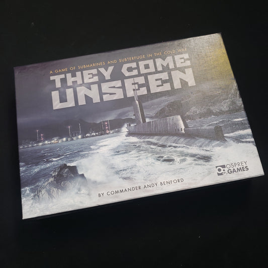 Image shows the front cover of the box of the board game They Come Unseen