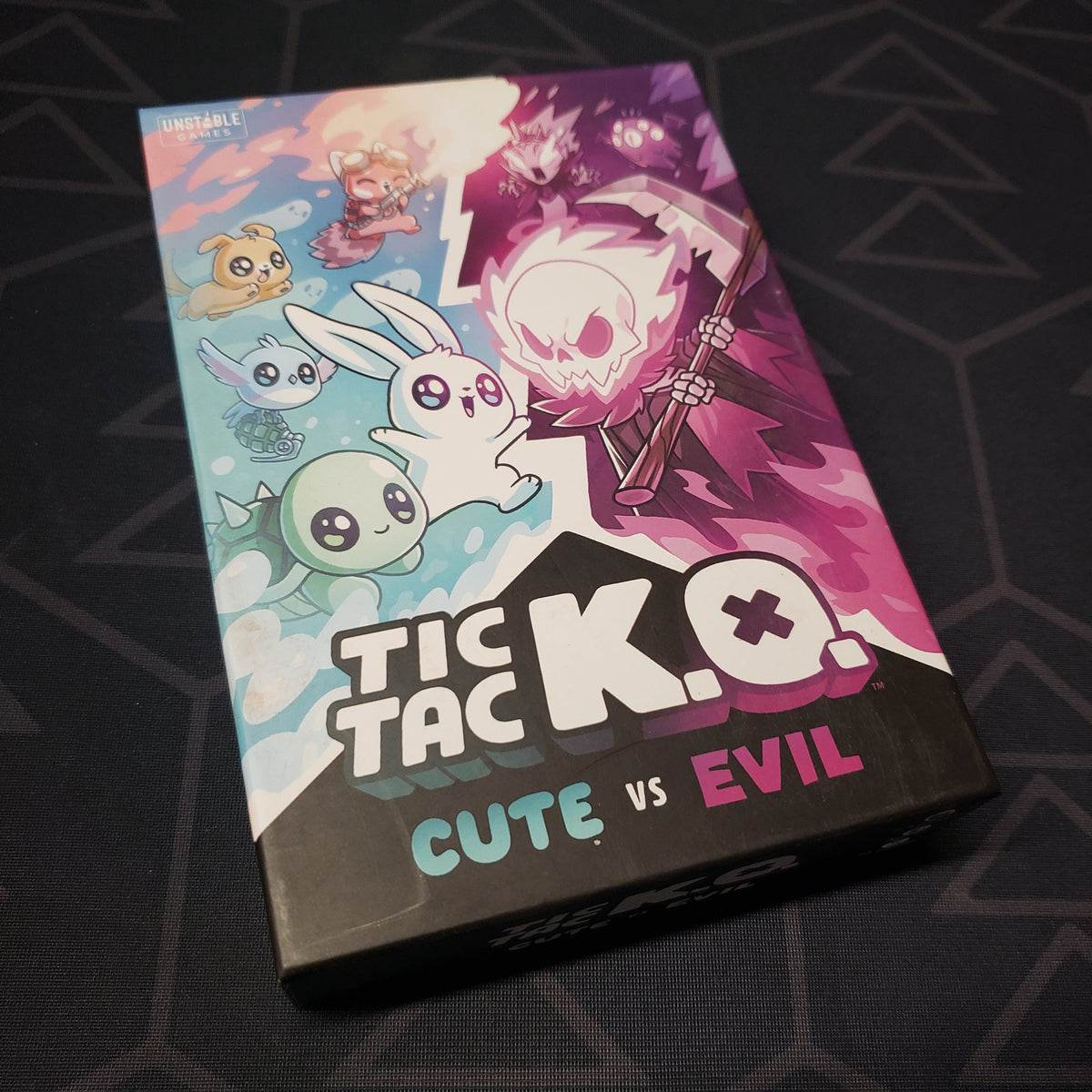 Image shows the front cover of the box for the Tic Tac K.O.: Cute vs Evil card game