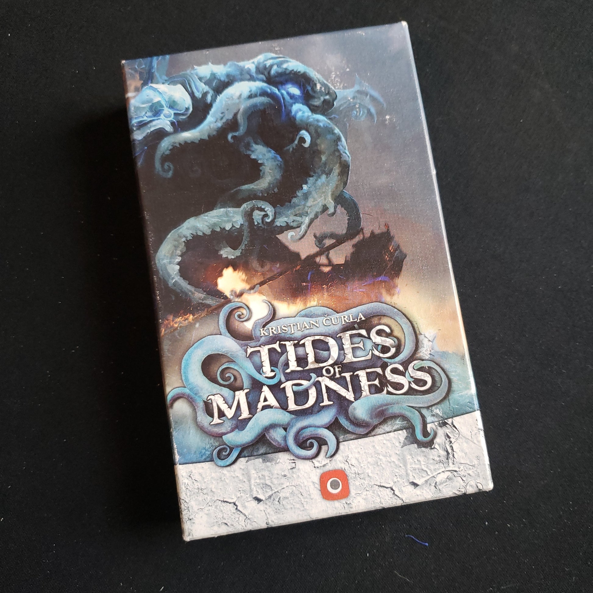 Image shows the front cover of the box of the Tides of Madness card game