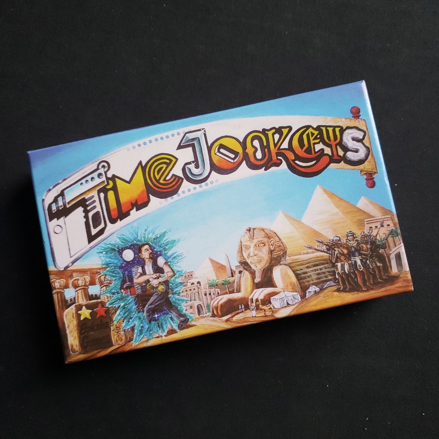 Image shows the front cover of the box of the Time Jockeys card game