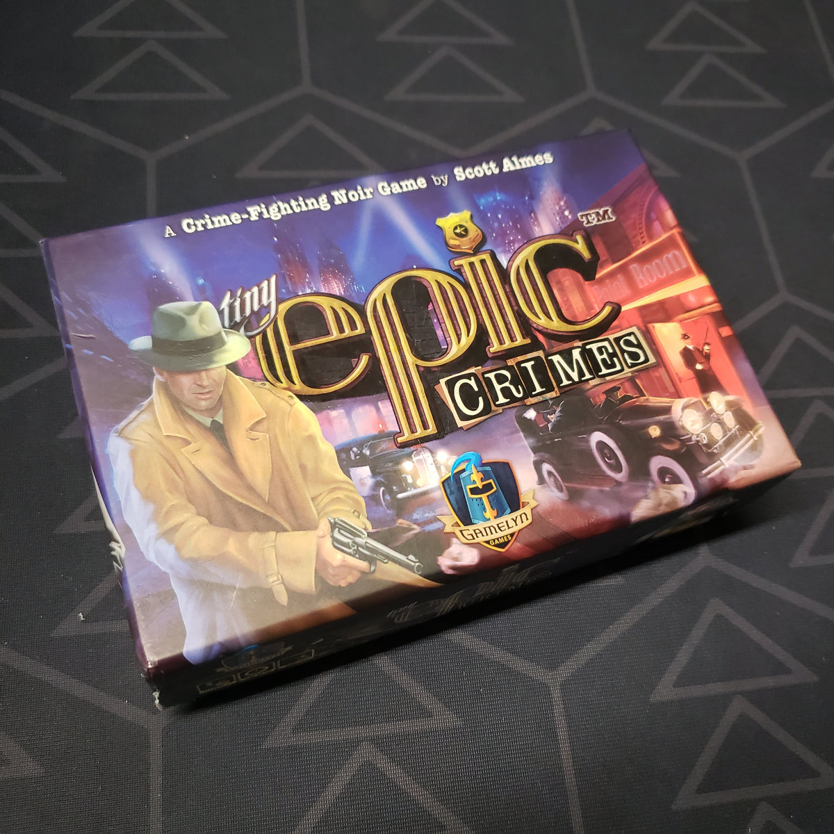 Image shows the front cover of the box for the Tiny Epic Crimes board game