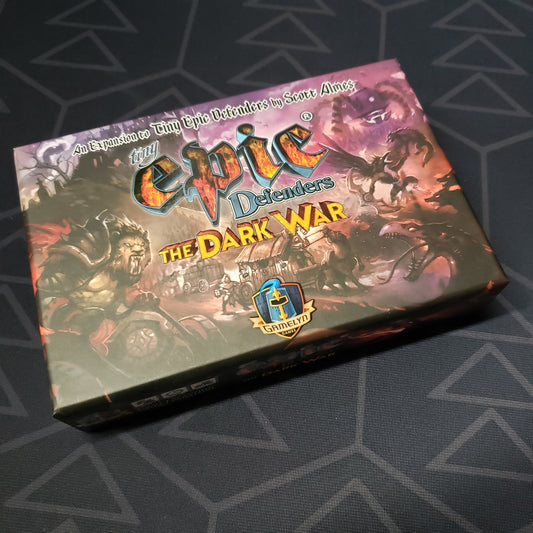 Image shows the front of the box for the Dark War expansion for the board game Tiny Epic Defenders