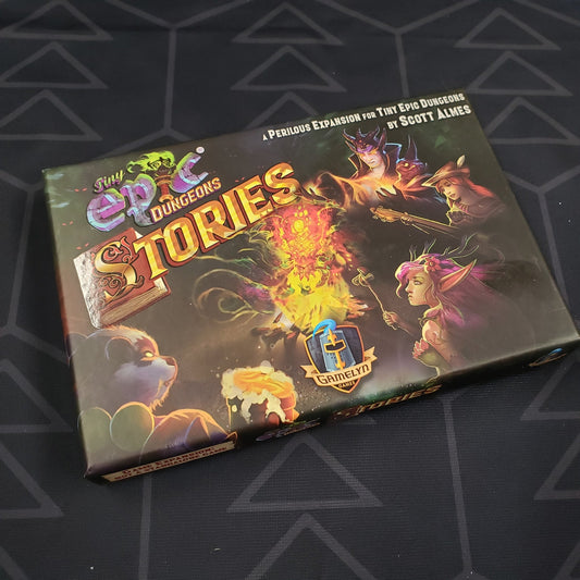 Image shows the front cover of the box of the Stories expansion for the board game Tiny Epic Dungeons