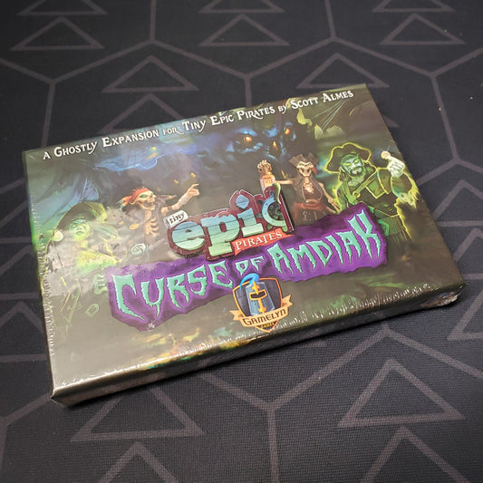 Image shows the front cover of the box of the Curse of Amdiak expansion for the board game Tiny Epic Pirates