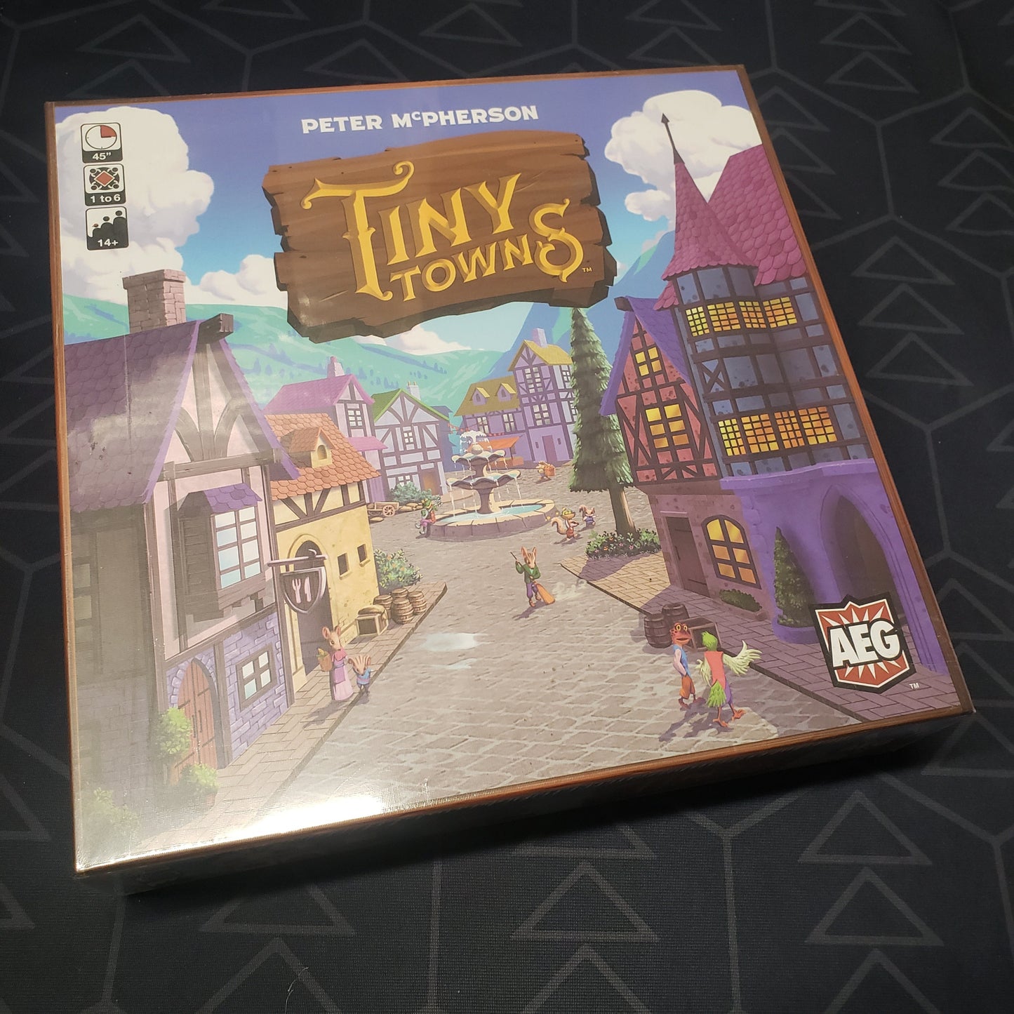 Image shows the front cover of the box of the Tiny Towns board game