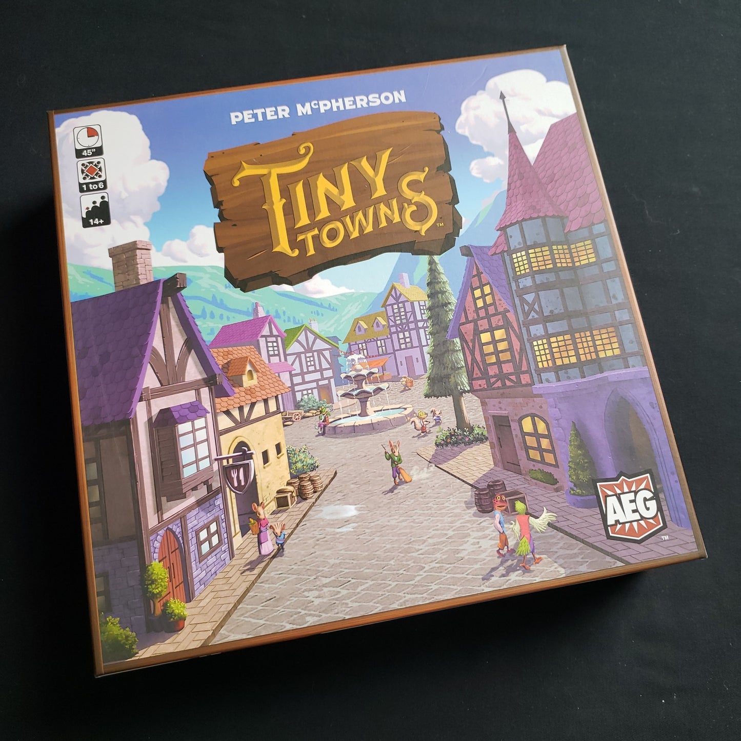 Image shows the front cover of the box of the Tiny Towns board game