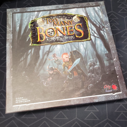 Image shows the front cover of the box of the Too Many Bones board game