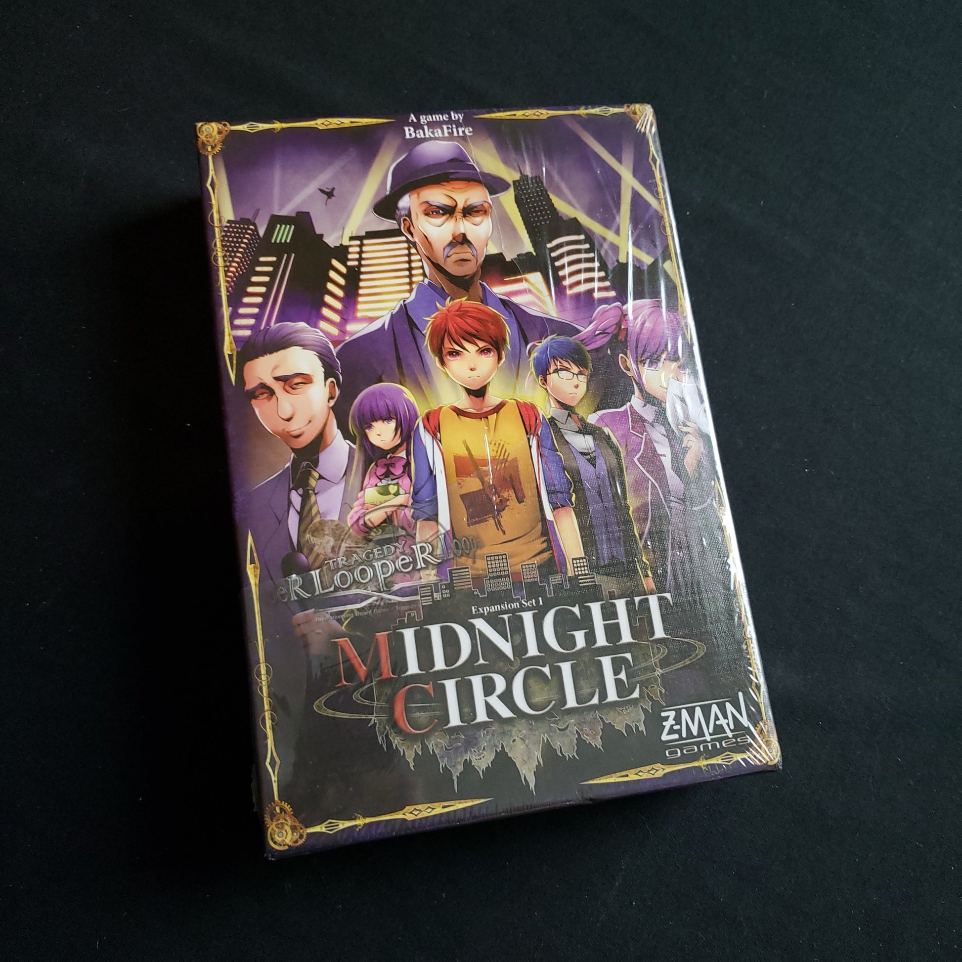 Image shows the front cover of the box of the Midnight Circle expansion for the board game Tragedy Looper