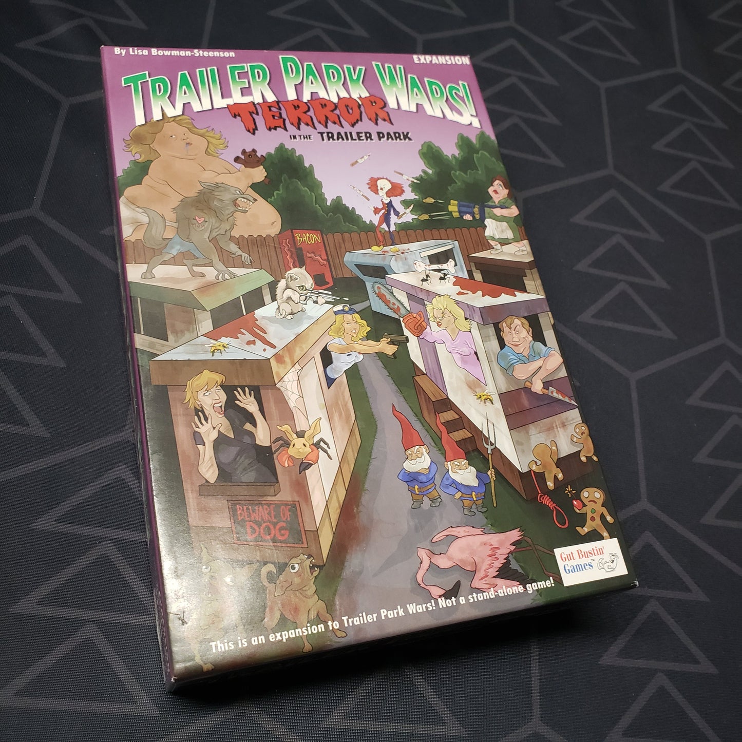 Image shows the front cover of the box of the Terror in the Trailer Park expansion for the board game Trailer Park Wars